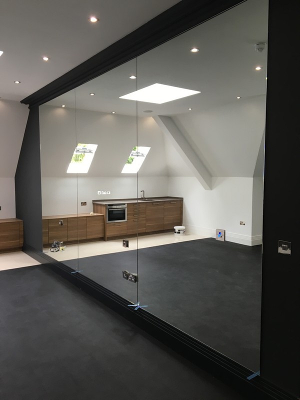 Frameless glass partition in loft conversion by Acton glaziers
