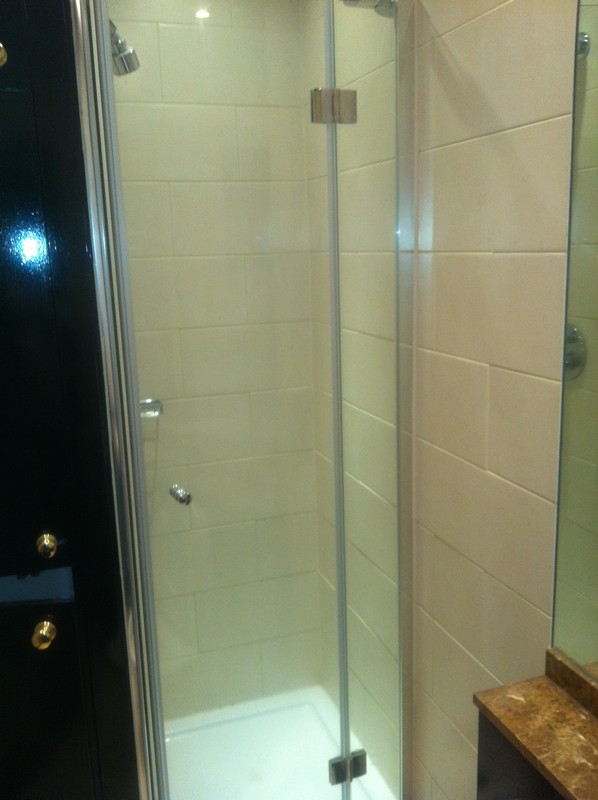 Frameless glass shower enclosure with chrome fittings in Acton